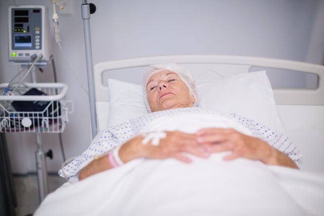 Senior woman patient lying on bed in hospital room