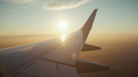 Airplane Wing above Cloudy Sky during Golden Hour Filming