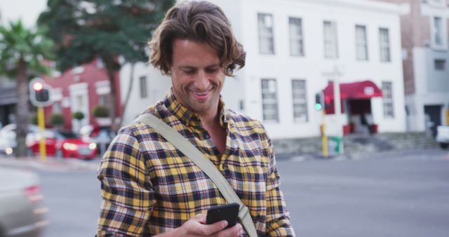 Smiling Young Man Looking at Smartphone on Urban Street - Download Free Stock Images Pikwizard.com