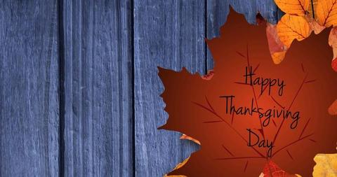 Thanksgiving greeting card featuring an arrangement of autumn leaves and a rustic wooden background with the text 'Happy Thanksgiving Day'. Ideal for use in holiday promotions, social media posts, and digital invitations to capture the autumn spirit during the Thanksgiving season.