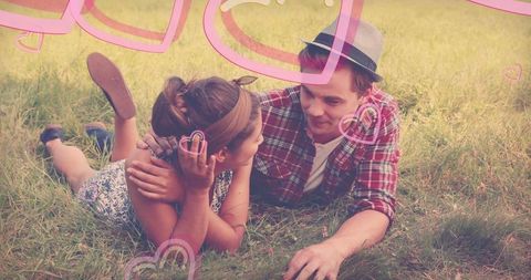 Couple lounging in meadow with heart accents