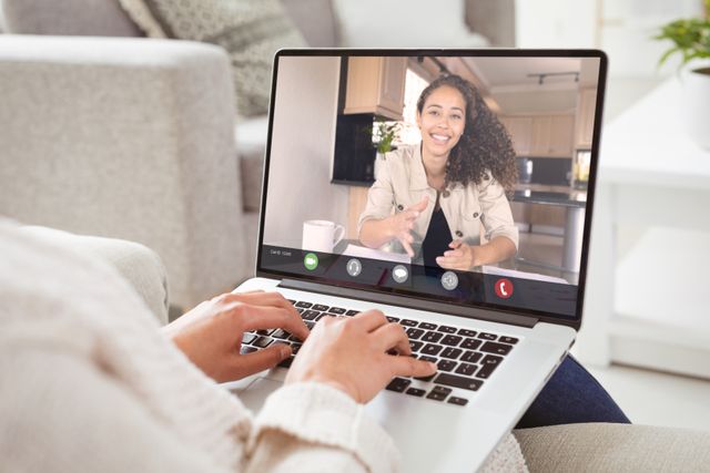 Biracial smiling businesswoman gesturing during video call with caucasian female colleague. unaltered, work from home, business, wireless technology, working, teamwork and office concept.