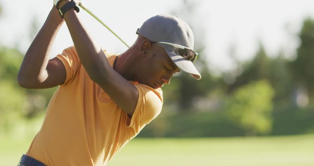 Image of african american man playing golf on golf field. sporty, active lifestyle and playing golf concept.