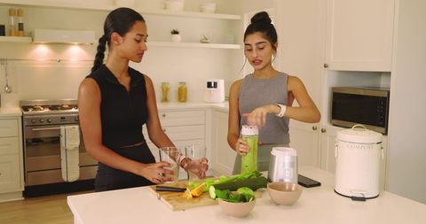 Diverse Women Making Green Juice in Modern Kitchen