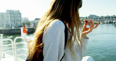 Woman Enjoying Phone Call by Sunny Waterfront