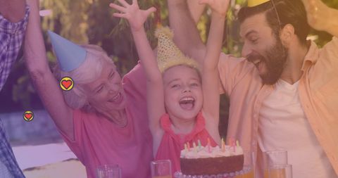 A lively family gathering takes place in an outdoor setting, featuring a multi-generational group celebrating a birthday. The older adult, young woman, and child wear party hats, expressing joy. Perfect for illustrating family values, generational connections, or promotional materials for events centered on family bonding.