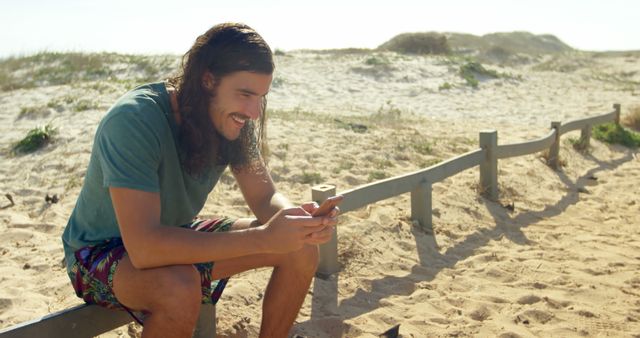 Young Man Relaxing on Beach Using Smartphone - Download Free Stock Images Pikwizard.com