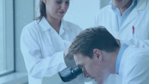 Scientists Collaborating in Modern Lab with Microscope