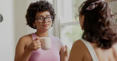 Friends enjoying coffee and engaging in heartfelt conversation indoors