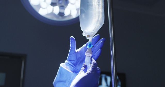 Medical professional preparing an IV drip in a hospital room. Ideal for illustrating healthcare medical procedures. Suitable for articles on hospital care, medical treatments, health services, nursing practices.
