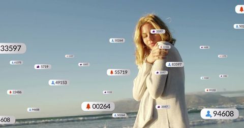Blonde woman hugging herself on beach surrounded by floating social media notifications