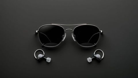 Sleek aviator sunglasses and wireless earbuds for bodyguards on black surface