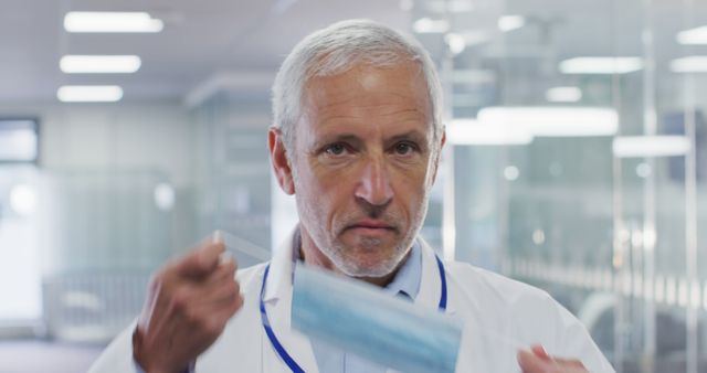 Elderly Male Doctor Removing Face Mask in Hospital - Download Free Stock Images Pikwizard.com