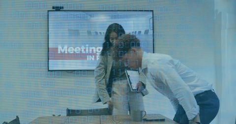 Team Reviewing Strategy Over Laptop in Modern Conference Room with Digital Data Overlay and Planning