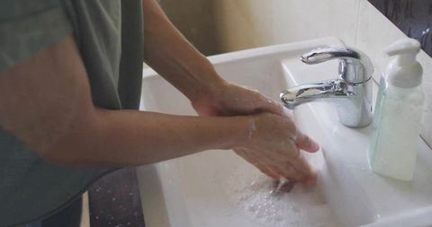 Washing hands hygiene at home bathroom sink with soap