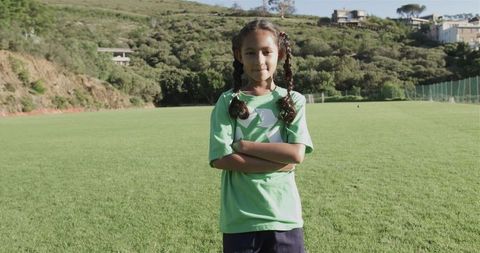 Confident Young Girl on Soccer Field in Green Recycling Shirt
