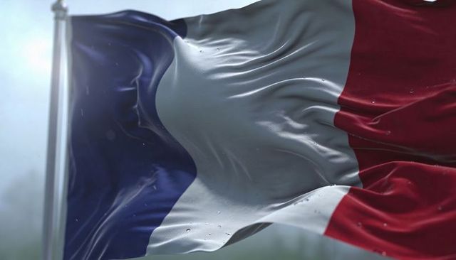 Waving french tricolor close-up with wet droplets and woven fabric texture