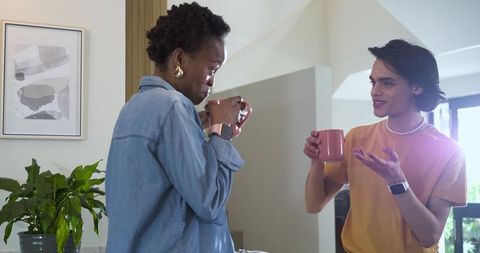 Casual morning coffee conversation at home kitchen counter with mugs and smartwatches
