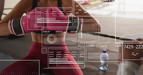 Kneeling woman pushing resistance band in boxing gym wearing pink gloves, digital hud overlay