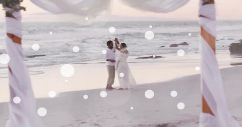Romantic Newlywed Couple Dancing on Beach at Sunset