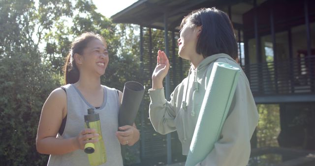 Two Young Women Enjoying Outdoor Exercise with Yoga Mats and Water Bottle - Download Free Stock Images Pikwizard.com