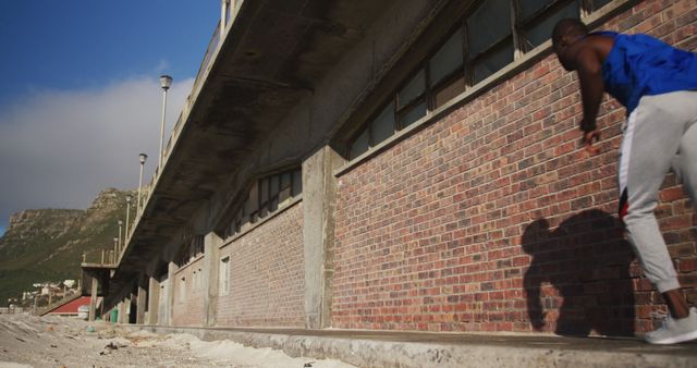 Athlete Performing Parkour Against an Industrial Brick Building - Download Free Stock Images Pikwizard.com