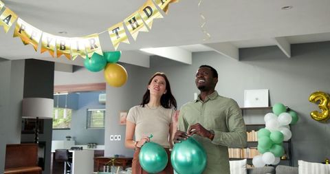 Happy Couple Preparing Birthday Decorations at Home