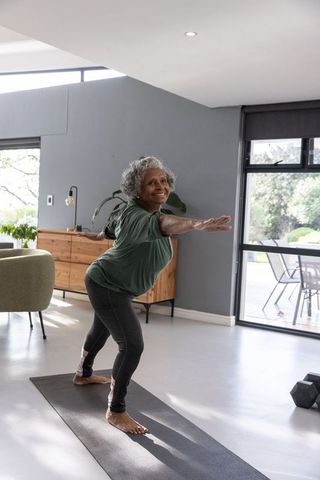 Senior Woman Practicing Yoga in Modern Living Room for Wellness