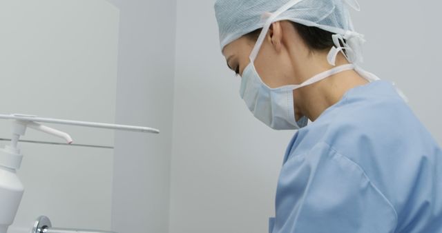 A surgeon is wearing a scrub suit, medical mask, and cap, preparing for surgery. This image can be used in healthcare articles, medical procedure guides, or hospital brochures.