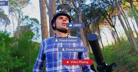 Man ready for adventure cycling on wooded trail with virtual social connectivity