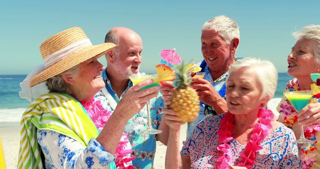Active senior friends gathering, holding tropical cocktails, and celebrating on a sunny beach. All are smiling and wearing floral shirts, with some donning leis and summer attire. Perfect for representing senior leisure activities, beach vacations, and vibrant retirement life. Ideal for retirement travel brochures, healthcare community marketing, and vacation advertisements.