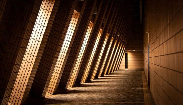 Angled Tiled Pillars Leading Toward Doorway with Dramatic Light and Geometric Rhythm