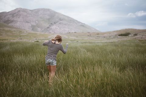 Woman Enjoying Freedom in Expansive Meadow with Mountains