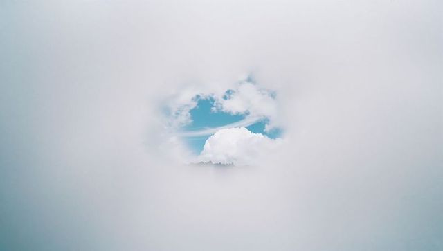 Ethereal Cloud Opening Reveals Blue Sky and Mountain Silhouette