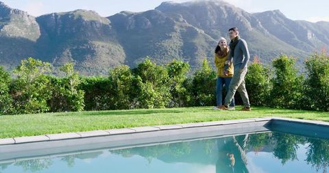 Couple Walking by Pool with Scenic Mountain View