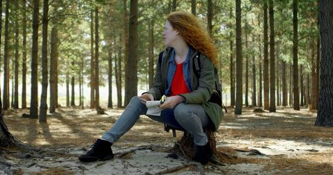 Contemplative Woman Relaxing with Notebook in Serene Forest
