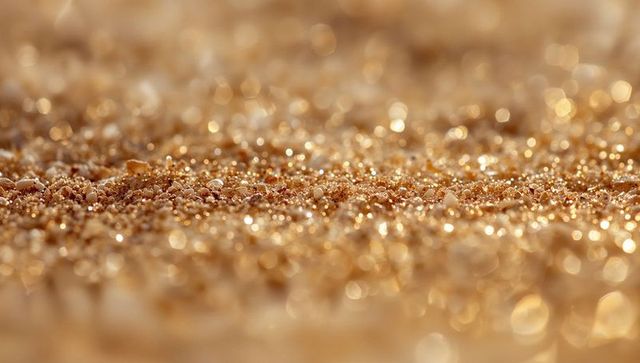 Glittering golden sand with warm bokeh effect
