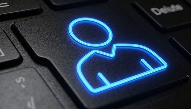 Neon blue user profile keycap glowing on laptop keyboard for login and identity security