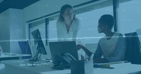 Colleagues Collaborating Over Laptop in Office Workspace
