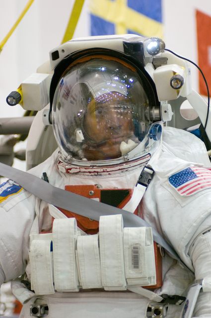 Astronaut attired in spacesuit, preparing for underwater training session at the Neutral Buoyancy Laboratory near Johnson Space Center. Ideal for content about space exploration, training techniques for astronauts, NASA missions, and professional preparation for spacewalks.