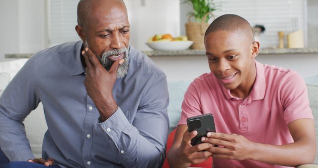 Grandfather and Grandson Enjoying Time Together Using Smartphone at Home - Download Free Stock Images Pikwizard.com