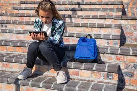 Young Girl Engaged with Tablet on Sunny Day Outdoors