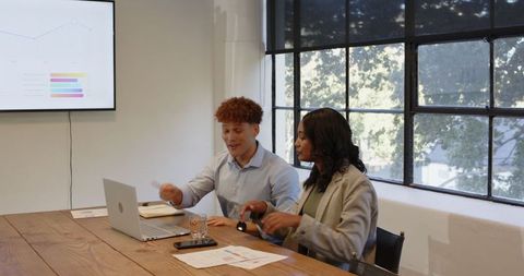 Corporate Team Discussing Business Strategies over Laptop in Office