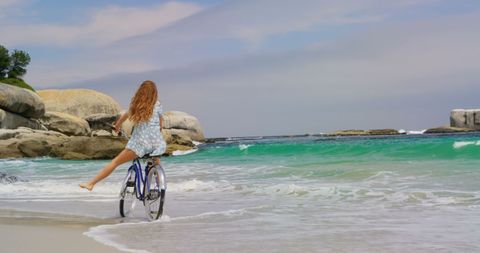 Joyful Woman Cycling on Tranquil Beach Shoreline 4k - Download Free Stock Images Pikwizard.com