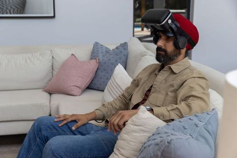 Man with red turban experiencing virtual reality at home