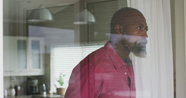 Middle Aged Man Looking Thoughtfully Through Window at Home - Download Free Stock Images Pikwizard.com