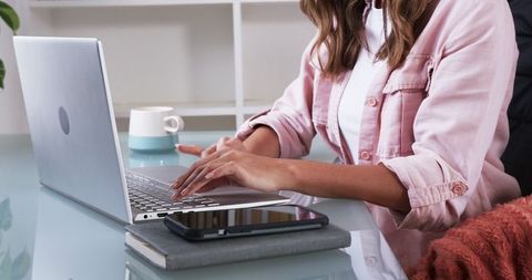 Woman Working on Laptop at Home Office with Coffee