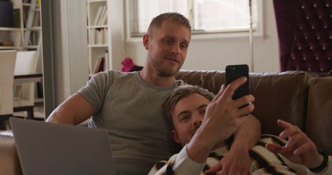 Caucasian Male Couple Relaxing With Smartphone and Laptop at Home - Download Free Stock Images Pikwizard.com