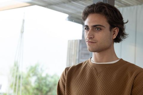Young Man in Minimalist Lounge Gazing Serenity through Window