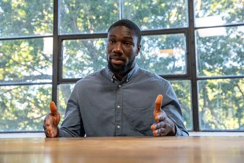 Professional Man Gesturing Business Meeting Near Large Windows